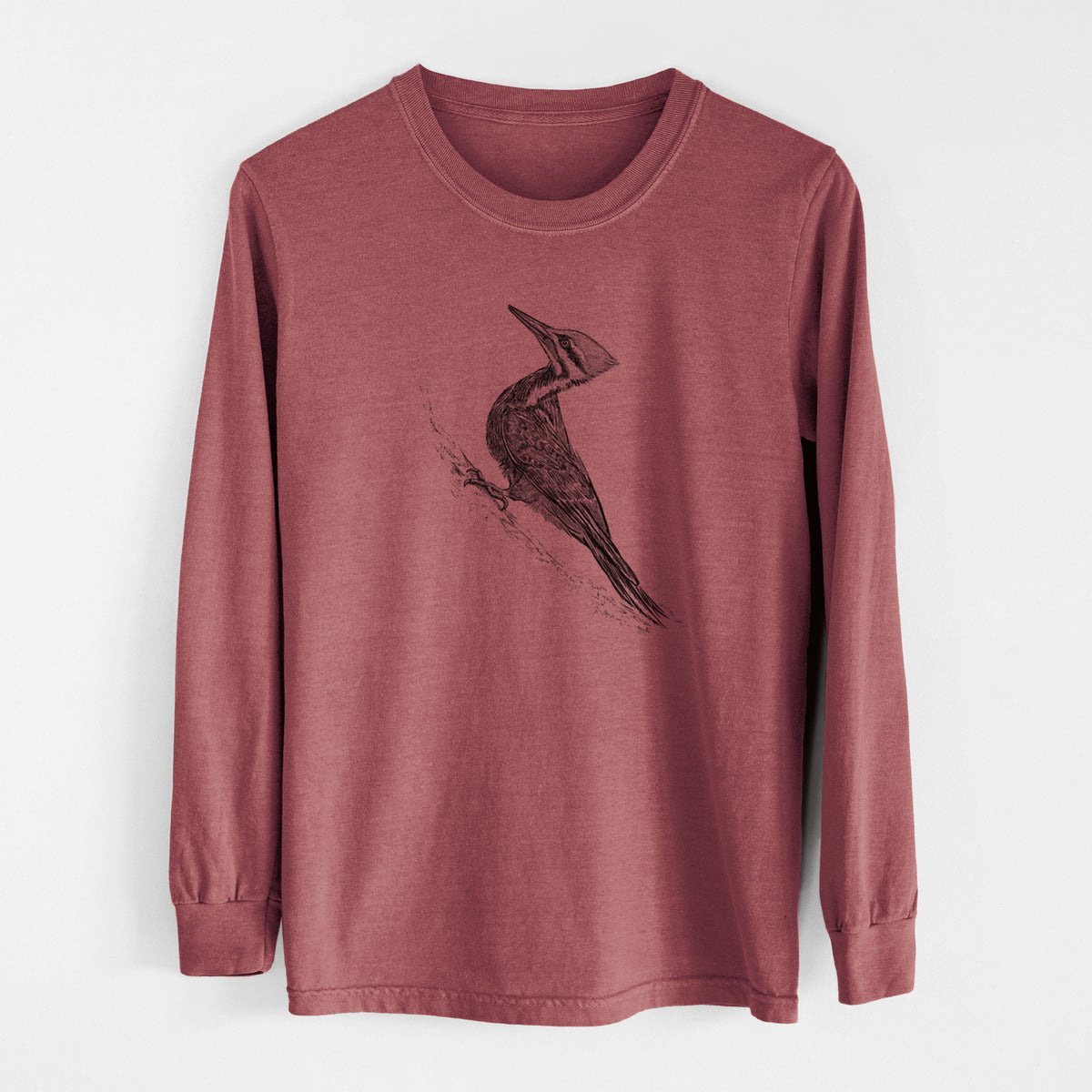 Brick red Comfort Colors long sleeve shirt laid flat, printed with a black ink illustration of a pileated woodpecker clinging to a tree trunk.