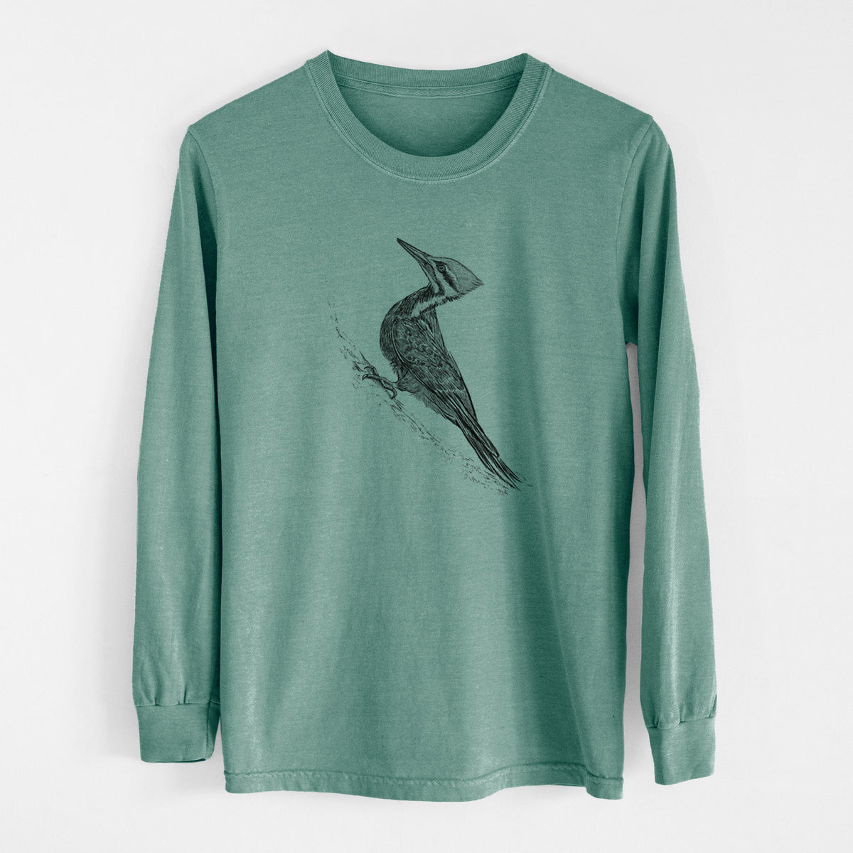 Pine green Comfort Colors long sleeve shirt laid flat, printed with a black ink illustration of a pileated woodpecker clinging to a tree trunk.