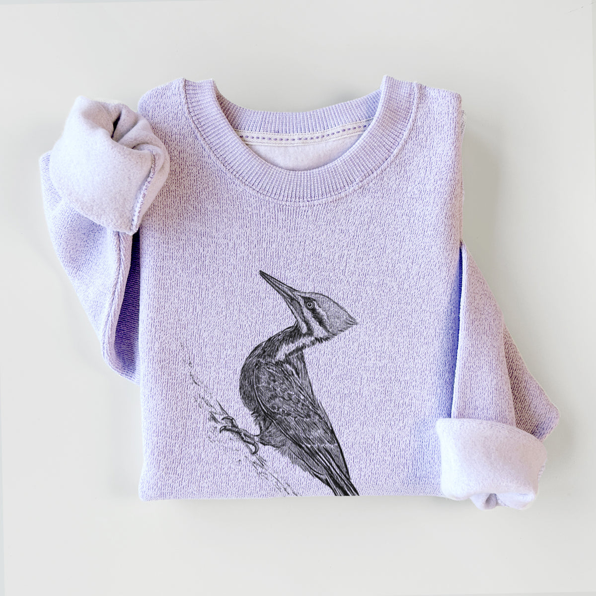 Ice purple knit sweatshirt printed with a black ink illustration of a pileated woodpecker clinging to a tree trunk, styled flat.