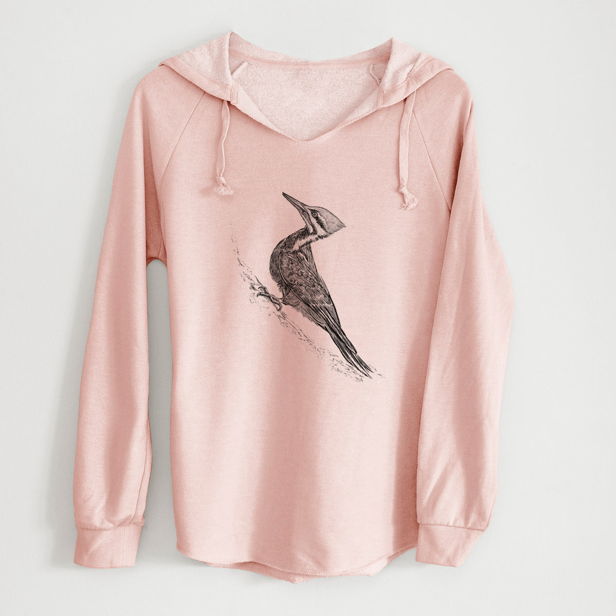 Blush pink women's Cali Wave hooded sweatshirt laid flat, printed with a black ink illustration of a pileated woodpecker clinging to a tree trunk.