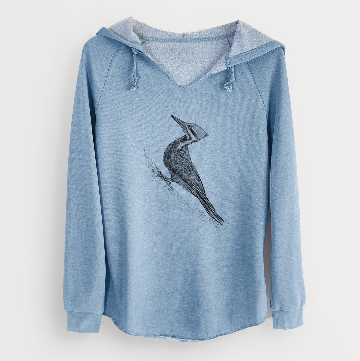 Misty blue women's Cali Wave hooded sweatshirt laid flat, printed with a black ink illustration of a pileated woodpecker clinging to a tree trunk.