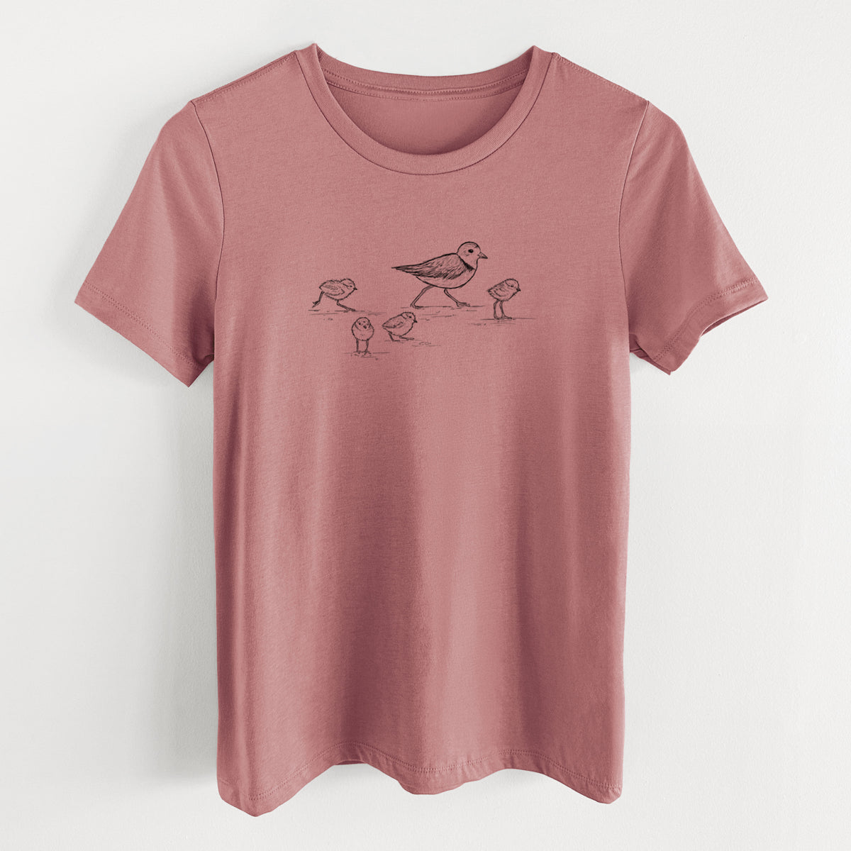 Mauve pink women's relaxed fit cotton t-shirt laid flat, printed with a black ink sketch of a piping plover with its chicks on the sand.