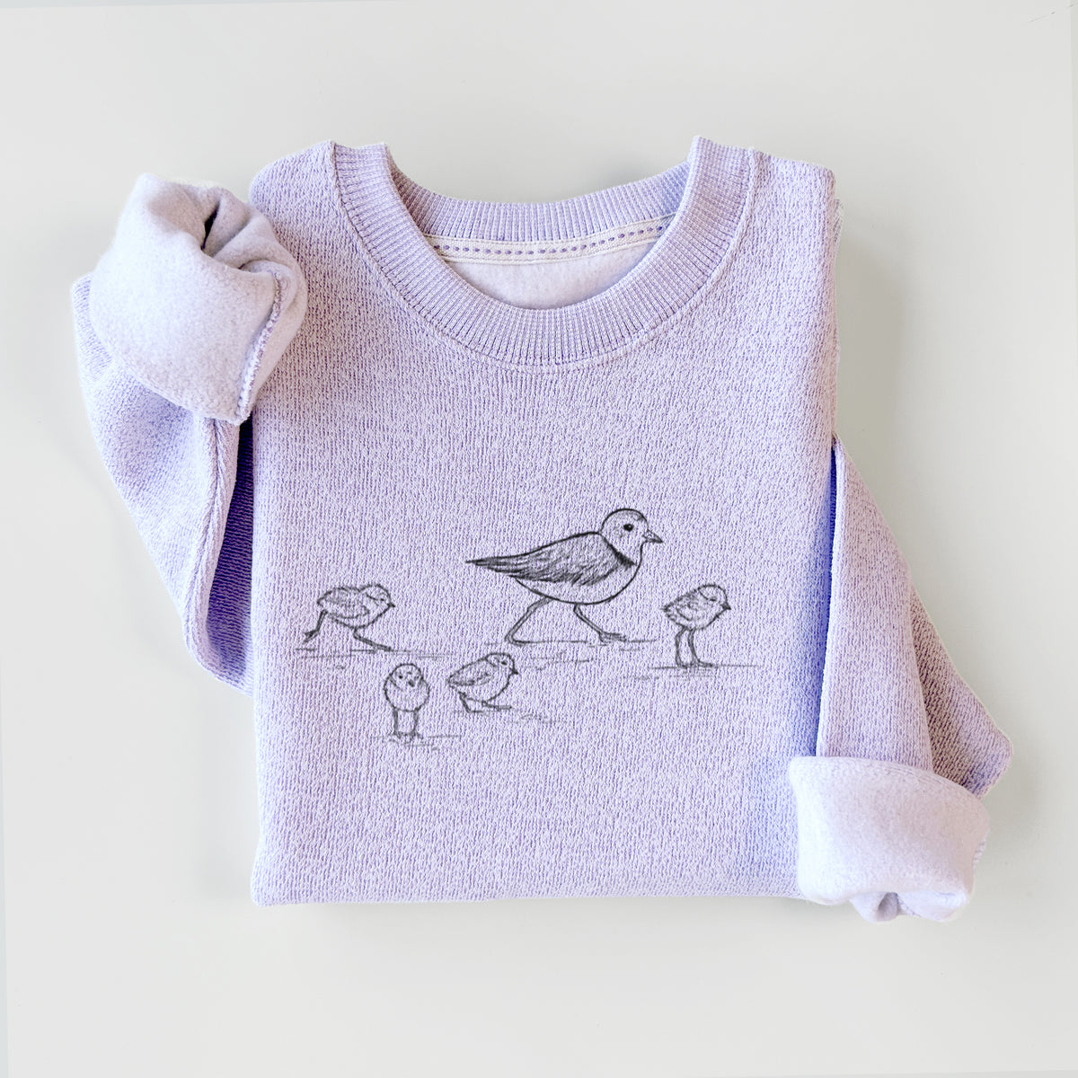 Ice purple knit sweatshirt printed with a black ink sketch of a piping plover with its chicks on the sand, styled flat.