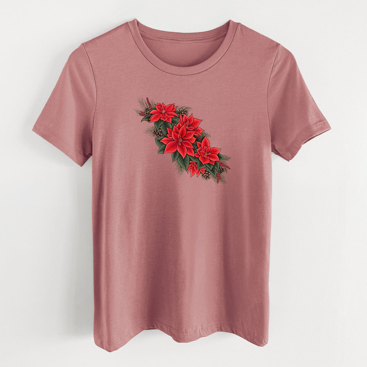 Mauve pink women's relaxed fit cotton t-shirt laid flat, printed with a full-color illustration of red poinsettia flowers with pine greenery and pine cones.