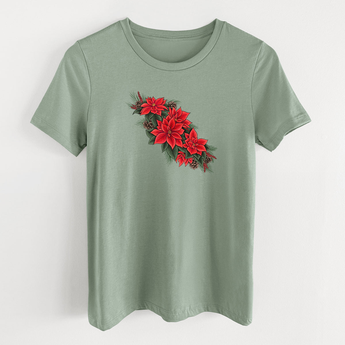 Sage green women's relaxed fit cotton t-shirt laid flat, printed with a full-color illustration of red poinsettia flowers with pine greenery and pine cones.