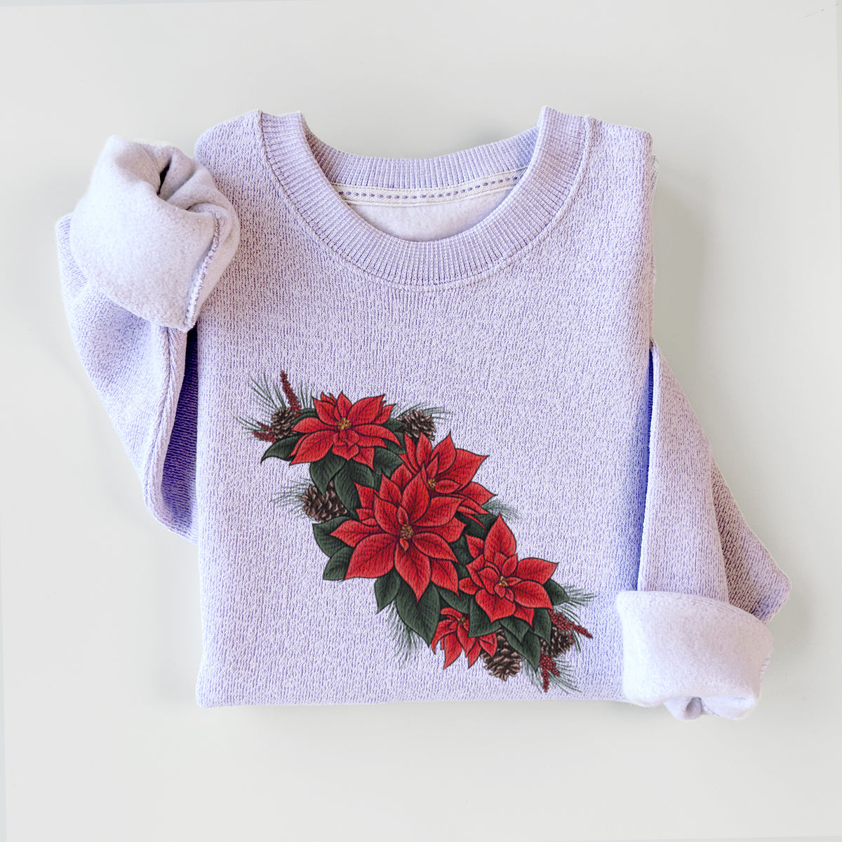 Ice purple knit sweatshirt printed with a full-color illustration of red poinsettia flowers with pine greenery and pine cones, styled flat.