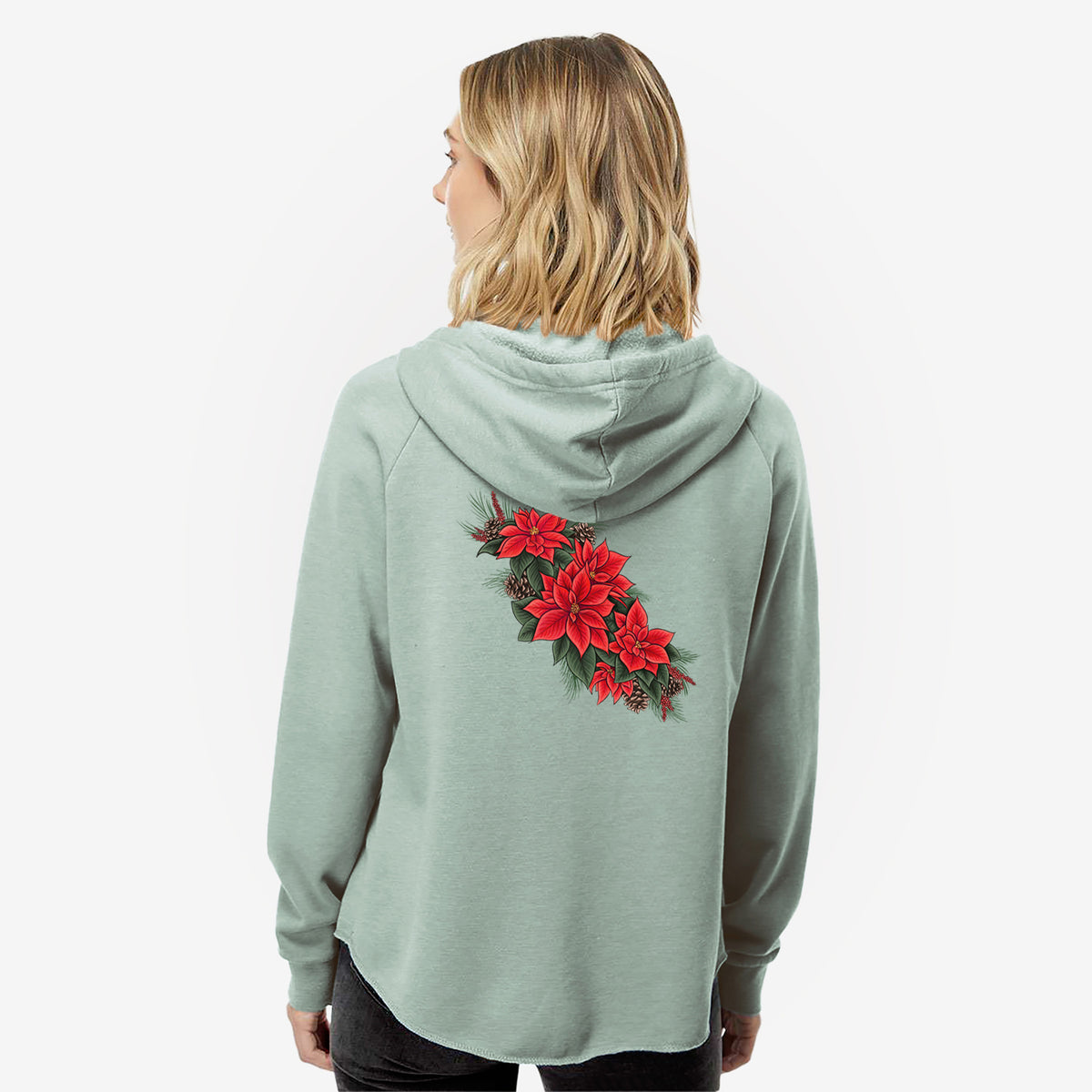 Woman wearing a sage green women's Cali Wave zip-up sweatshirt printed with a full-color illustration of red poinsettia flowers with pine greenery and pine cones, seen from behind.