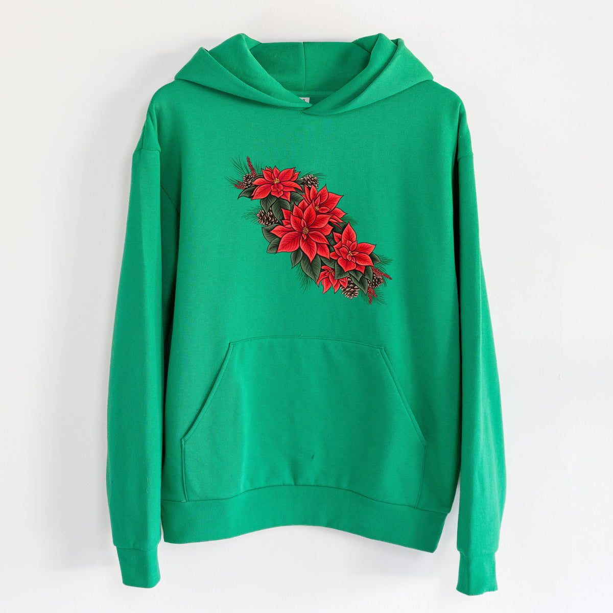 Winter Poinsettias - Euphorbia pulcherrima - Statement Midweight Hoodie in Kelly Green, hanging on a white wall, with a front kangaroo pocket and no drawcords.