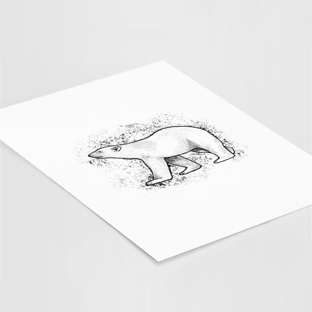 Art print of a black ink illustration of a polar bear walking across snow, lying at an angle on a white surface.