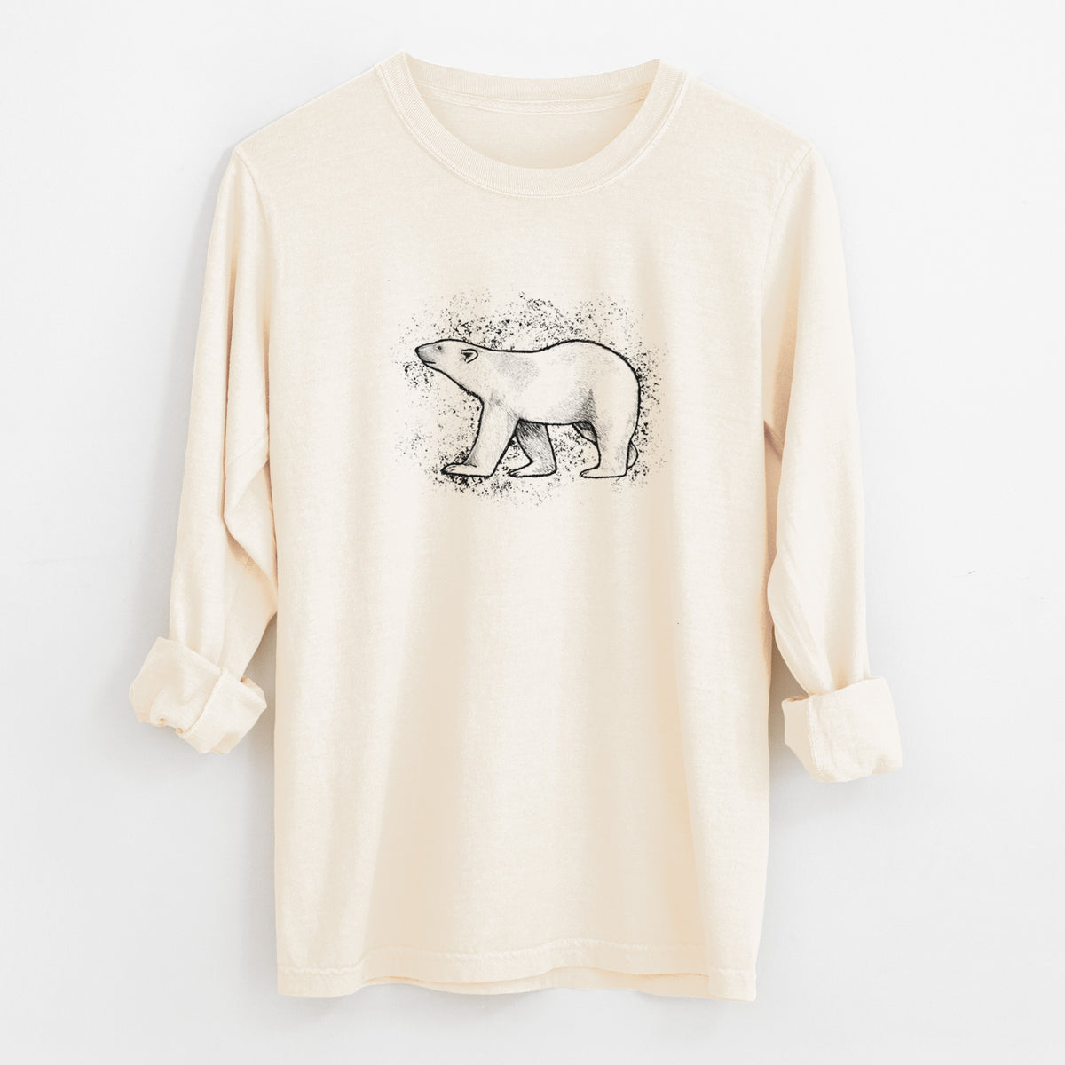 Ivory Comfort Colors long sleeve shirt laid flat with the cuffs rolled, printed with a black ink illustration of a polar bear walking across snow.