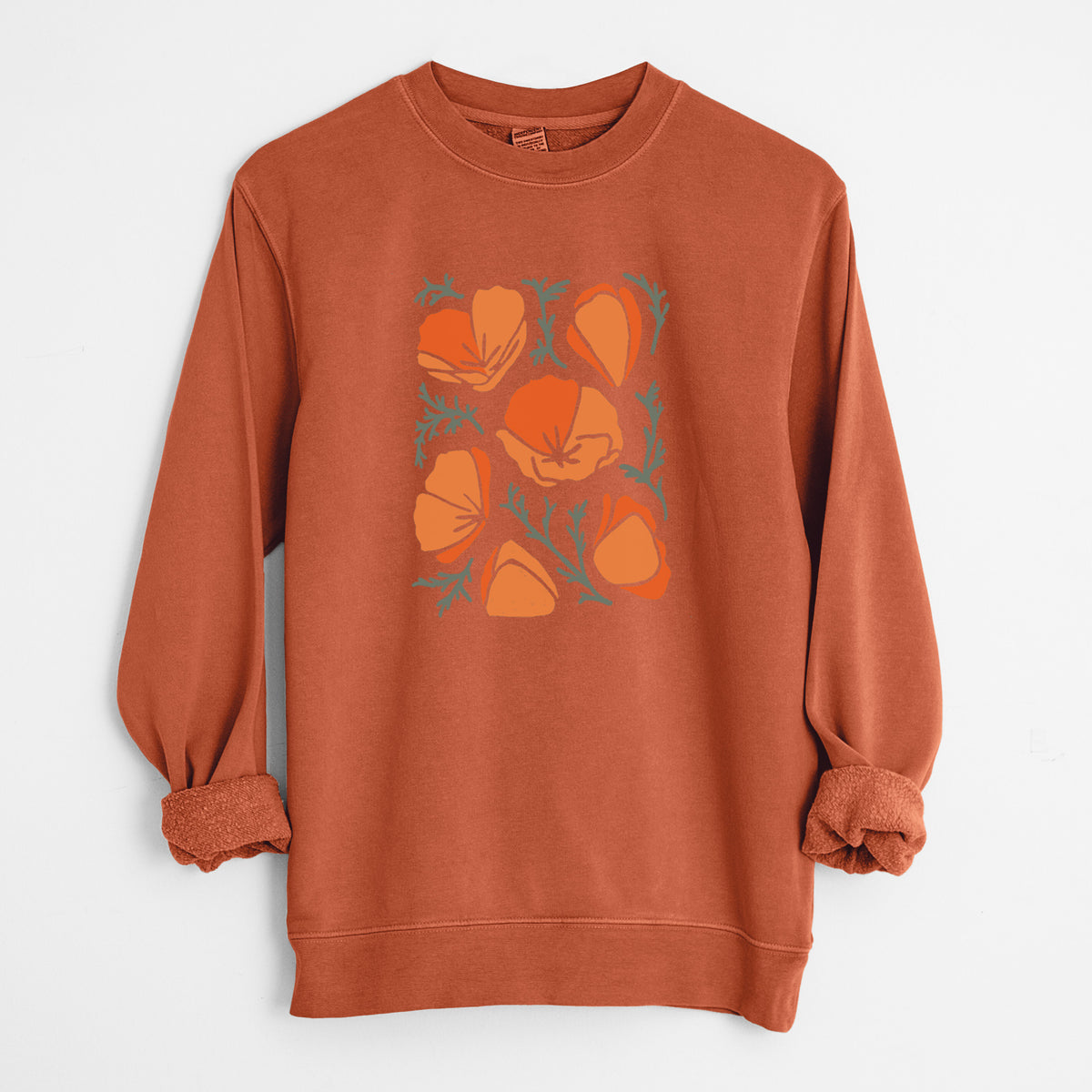 Amber orange pigment dyed crewneck sweatshirt laid flat with the sleeves rolled, printed with a full-color illustration of orange California poppies with blue-green leaves.