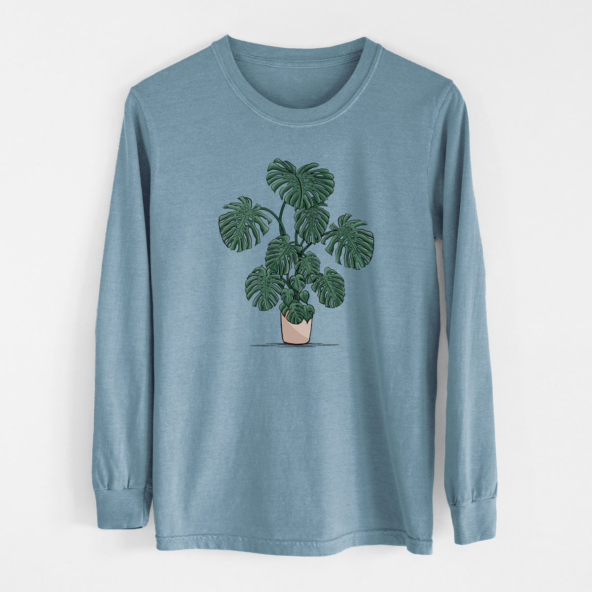 Steel blue Comfort Colors long sleeve shirt laid flat, printed with a full-color illustration of a large potted Monstera plant.