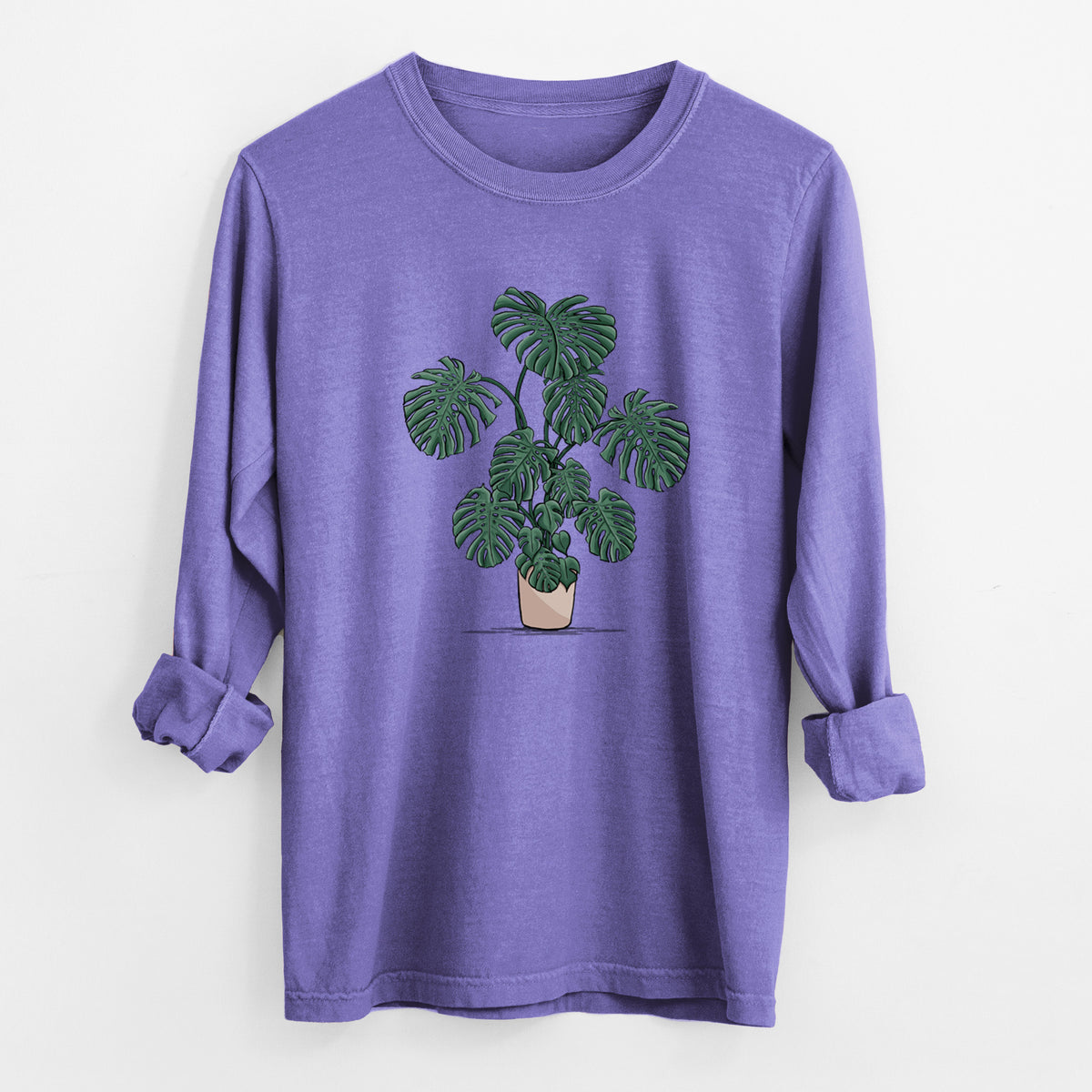 Violet purple Comfort Colors long sleeve shirt laid flat with the cuffs rolled, printed with a full-color illustration of a large potted Monstera plant.