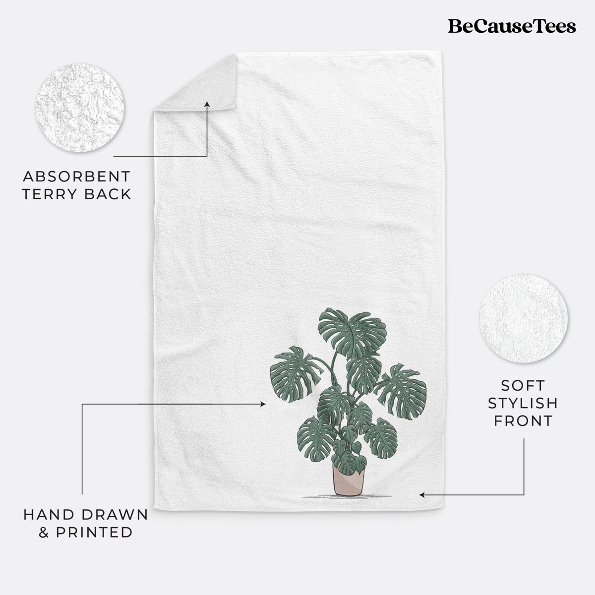 White hand towel printed with a full-color illustration of a large potted Monstera plant.