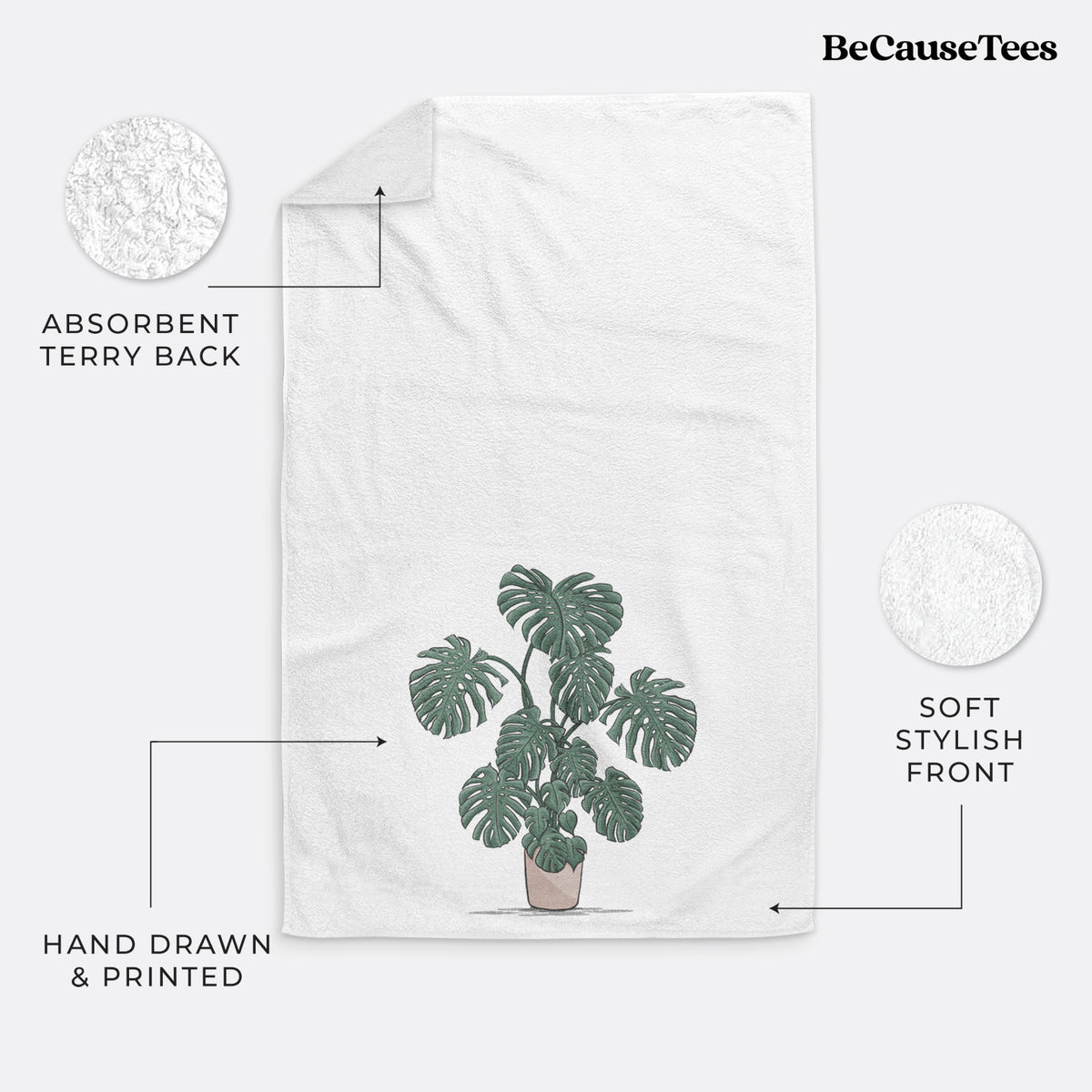 White hand towel printed with a full-color illustration of a large potted Monstera plant.