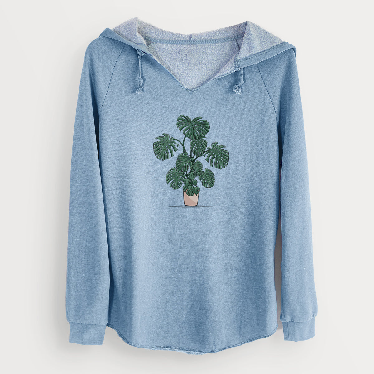 Misty blue women's Cali Wave hooded sweatshirt laid flat, printed with a full-color illustration of a large potted Monstera plant.