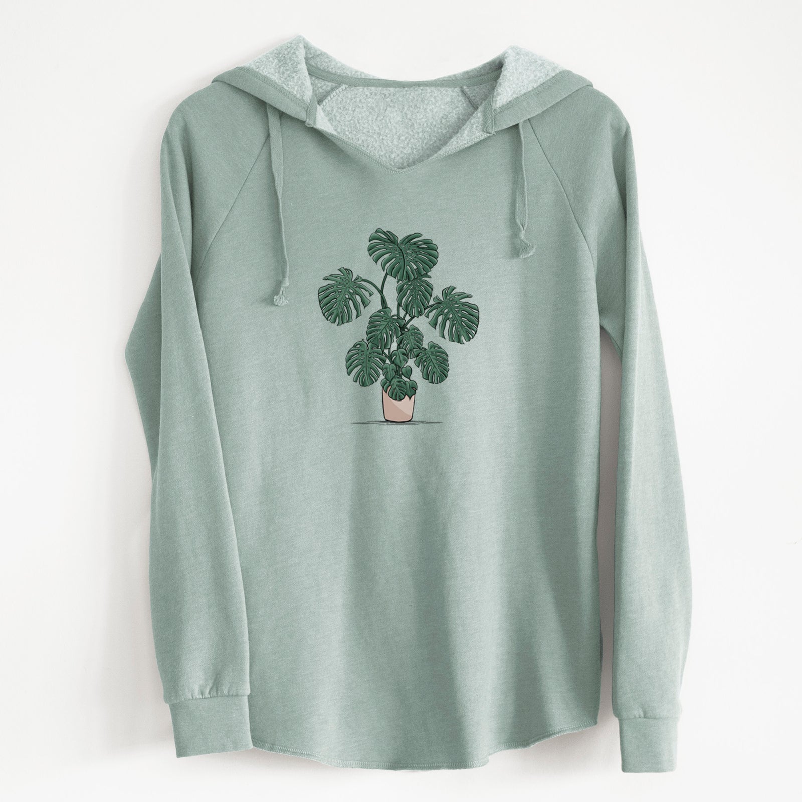 Sage green women's Cali Wave hooded sweatshirt laid flat, printed with a full-color illustration of a large potted Monstera plant.