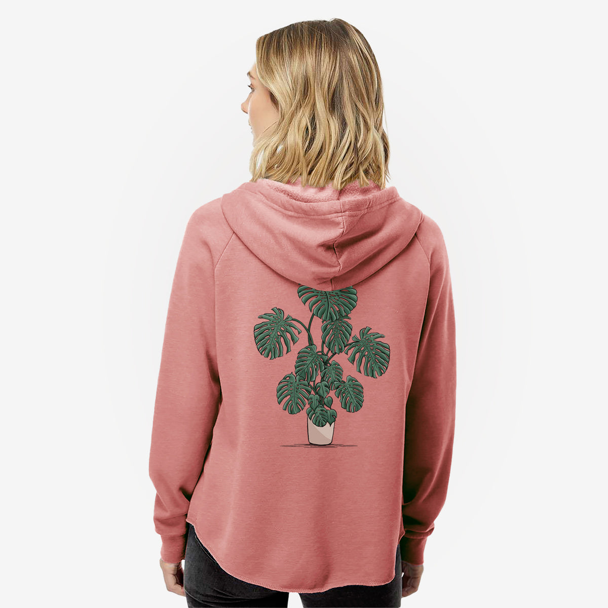 Woman wearing a dusty rose women's Cali Wave zip-up sweatshirt printed with a full-color illustration of a large potted Monstera plant, seen from behind.