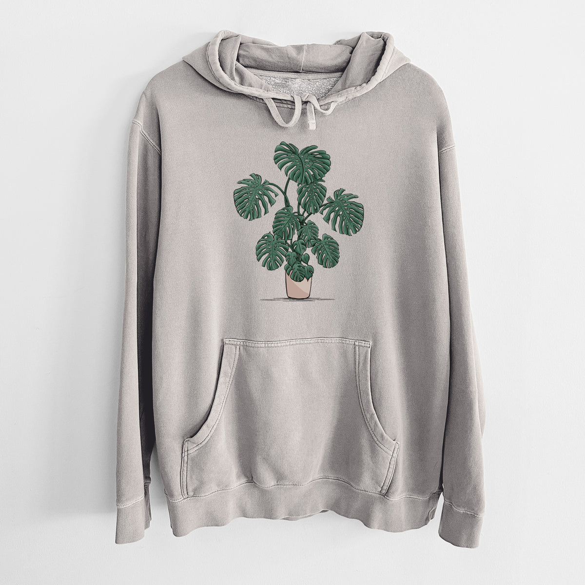 Cement grey pigment dyed hoodie laid flat, printed with a full-color illustration of a large potted Monstera plant.