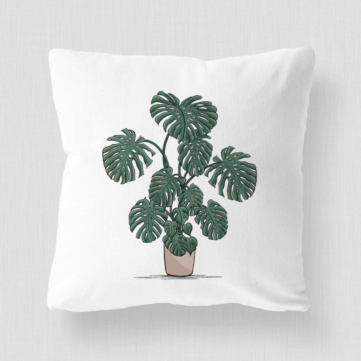 White pillow cover printed with a full-color illustration of a large potted Monstera plant.