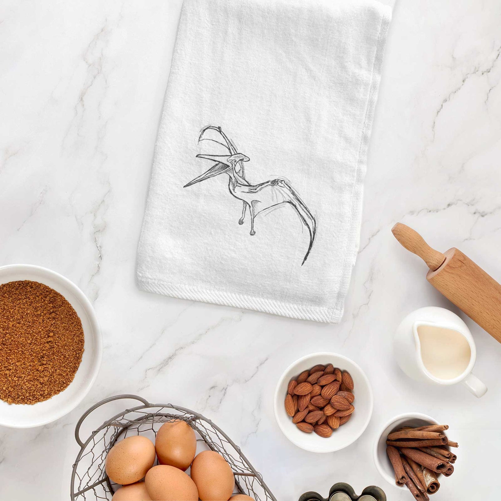 White hand towel printed with a black ink illustration of a Pteranodon in flight.