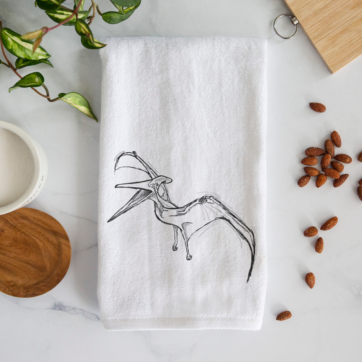 White hand towel printed with a black ink illustration of a Pteranodon in flight.