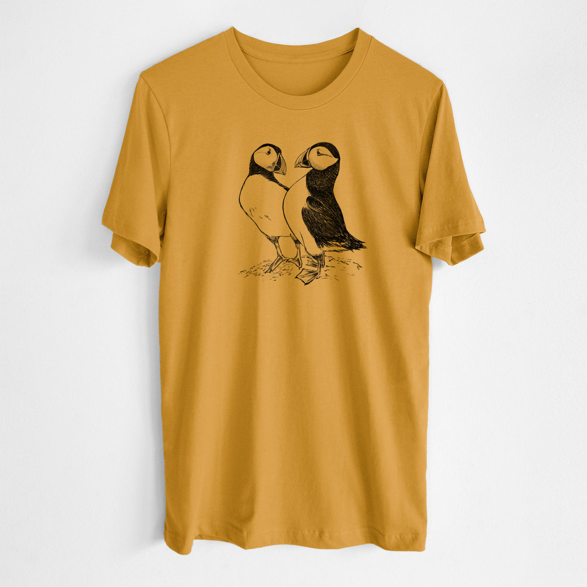 Honeycomb yellow lightweight cotton t-shirt laid flat, printed with a detailed black ink illustration of two Atlantic puffins standing side by side.