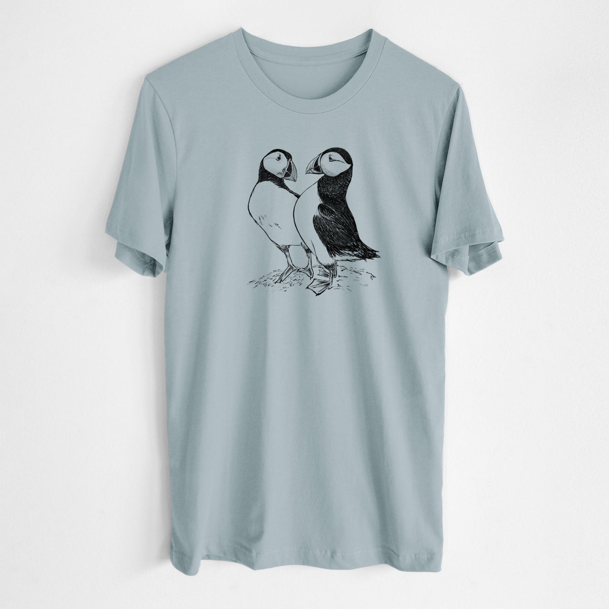 Vintage denim lightweight cotton t-shirt laid flat, printed with a detailed black ink illustration of two Atlantic puffins standing side by side.