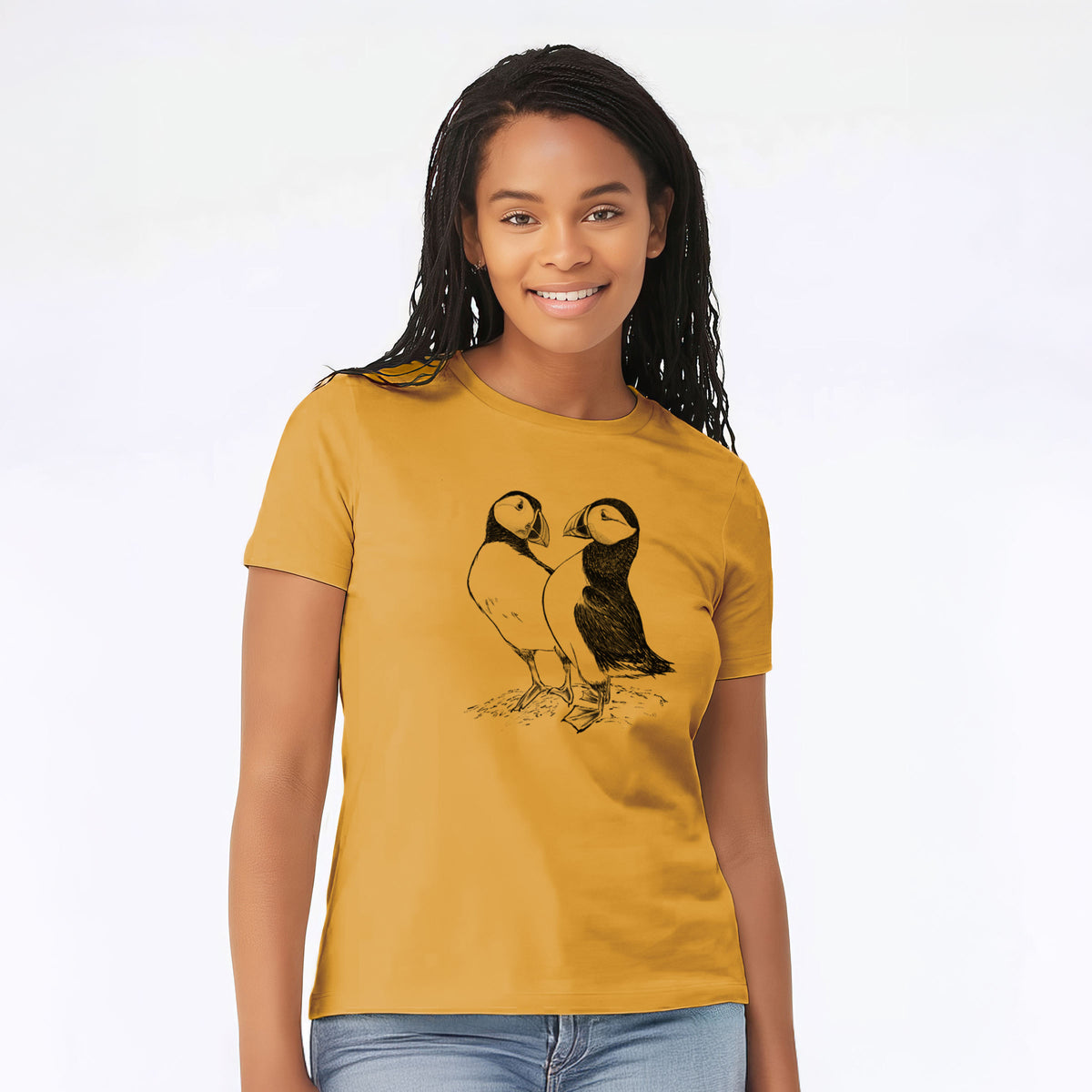 Woman wearing a mustard yellow women's relaxed fit cotton t-shirt printed with a detailed black ink illustration of two Atlantic puffins standing side by side.