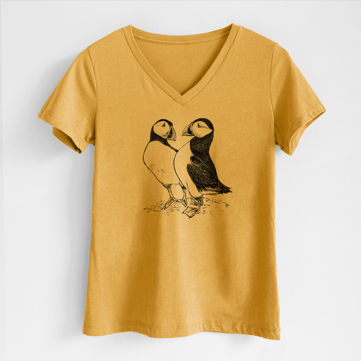 Honeycomb yellow women's relaxed fit cotton V-neck t-shirt laid flat, printed with a detailed black ink illustration of two Atlantic puffins standing side by side.