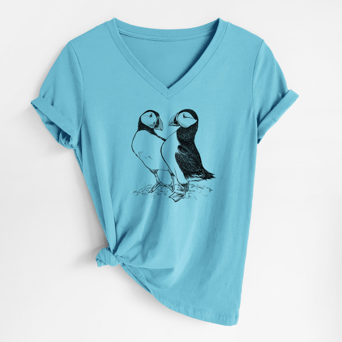 Turquoise women's relaxed fit cotton V-neck t-shirt laid flat, printed with a detailed black ink illustration of two Atlantic puffins standing side by side.
