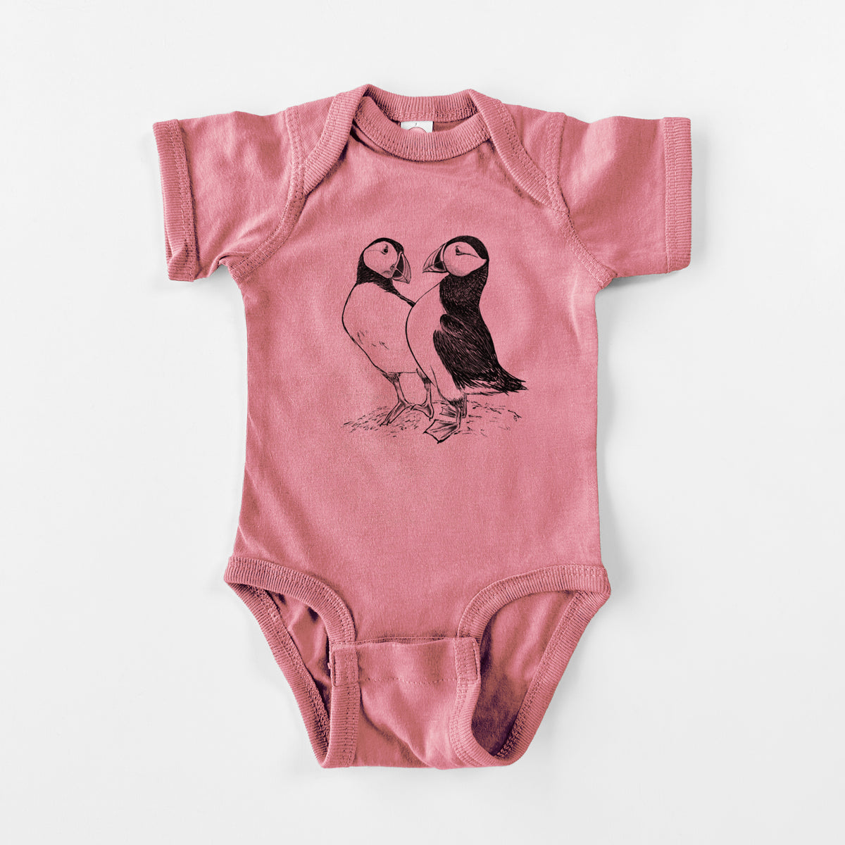 Mauve pink baby bodysuit laid flat, printed with a detailed black ink illustration of two Atlantic puffins standing side by side.