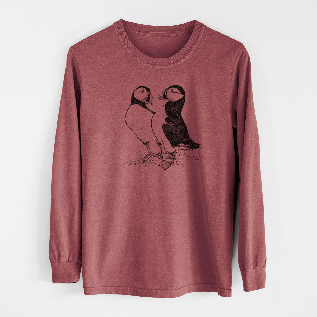 Brick red Comfort Colors long sleeve shirt laid flat, printed with a detailed black ink illustration of two Atlantic puffins standing side by side.