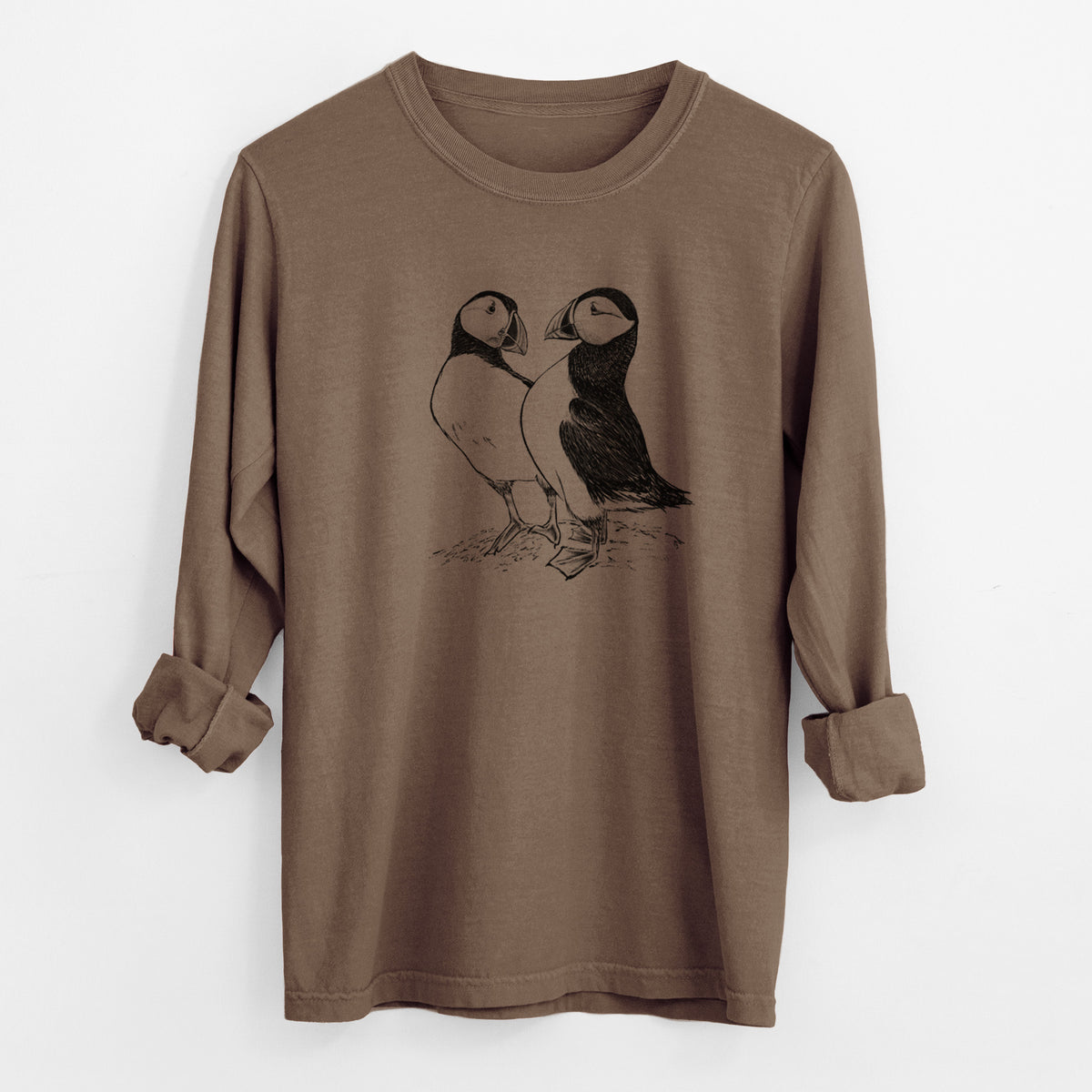 Espresso brown Comfort Colors long sleeve shirt laid flat with the cuffs rolled, printed with a detailed black ink illustration of two Atlantic puffins standing side by side.