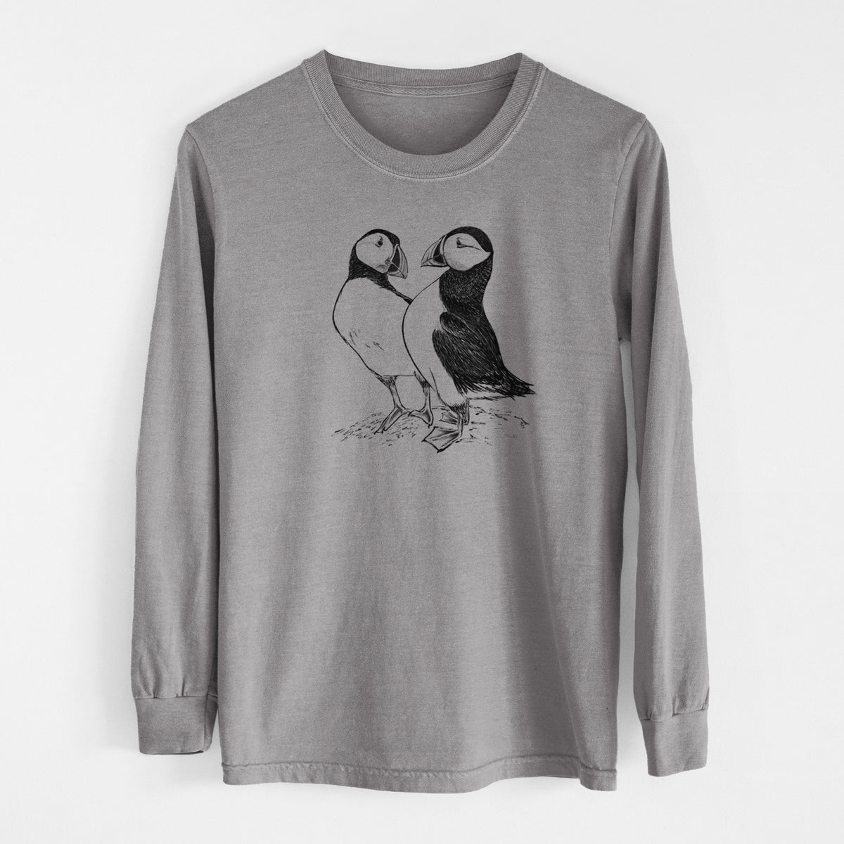 Grey Comfort Colors long sleeve shirt laid flat, printed with a detailed black ink illustration of two Atlantic puffins standing side by side.