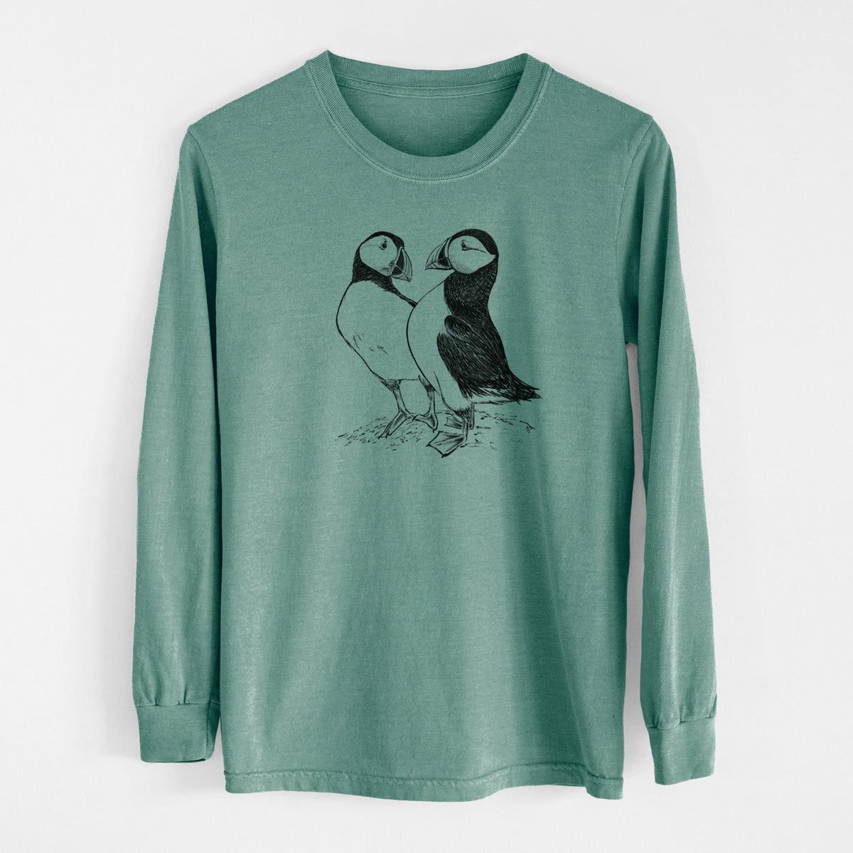 Pine green Comfort Colors long sleeve shirt laid flat, printed with a detailed black ink illustration of two Atlantic puffins standing side by side.