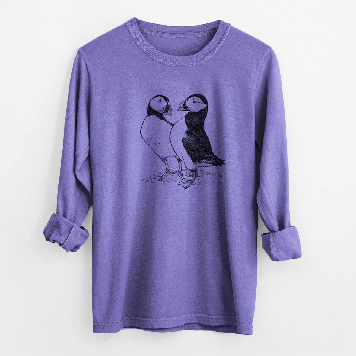 Violet purple Comfort Colors long sleeve shirt laid flat with the cuffs rolled, printed with a detailed black ink illustration of two Atlantic puffins standing side by side.