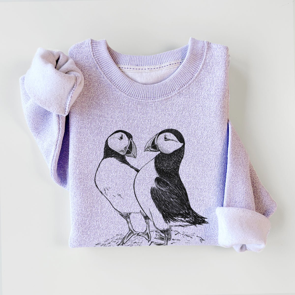 Ice purple knit sweatshirt printed with a detailed black ink illustration of two Atlantic puffins standing side by side, styled flat.
