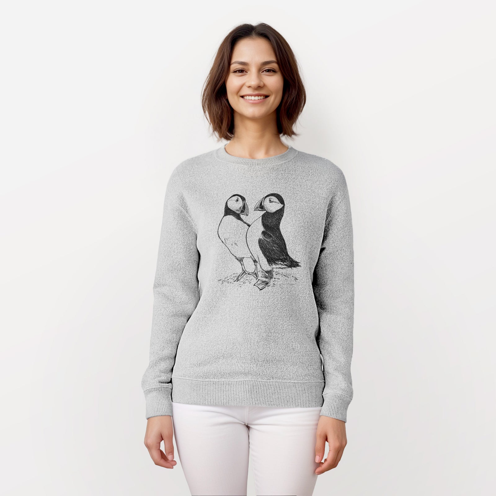 Salt and pepper knit sweatshirt laid flat, printed with a detailed black ink illustration of two Atlantic puffins standing side by side.