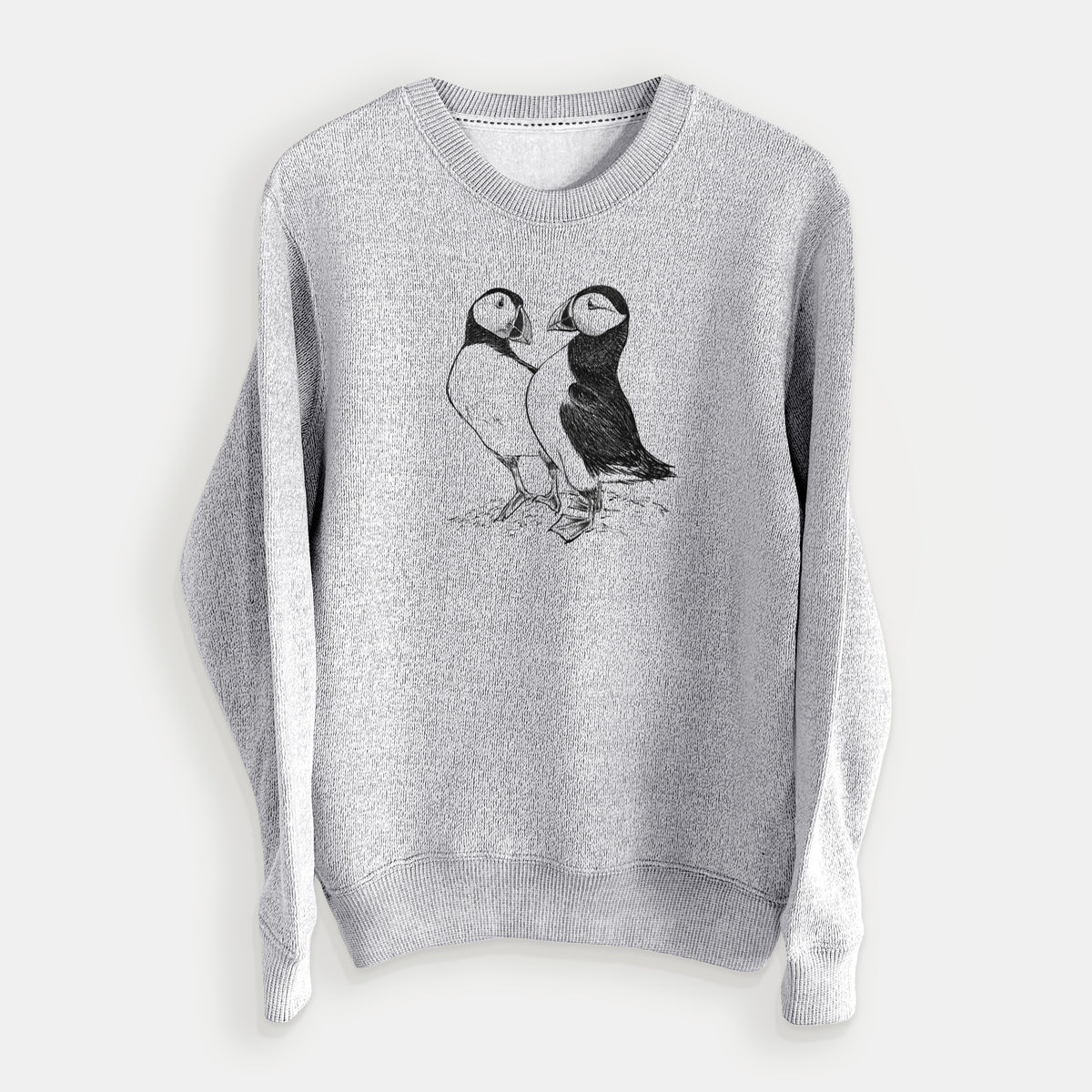 Salt and pepper knit sweatshirt laid flat, printed with a detailed black ink illustration of two Atlantic puffins standing side by side.