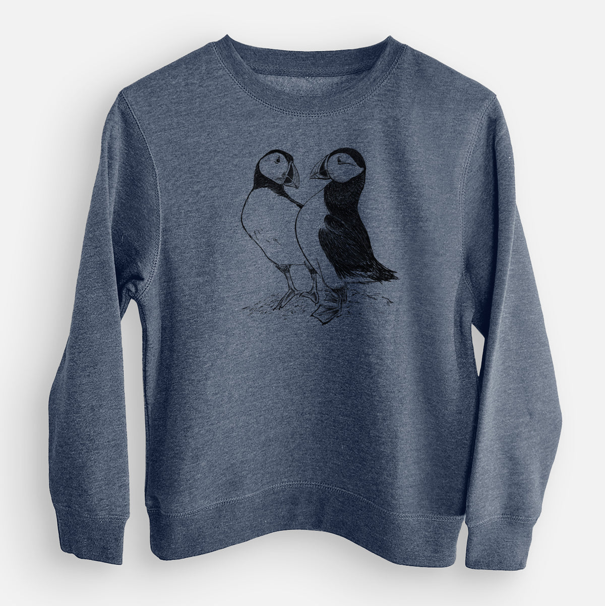 Storm blue youth crewneck sweatshirt laid flat, printed with a detailed black ink illustration of two Atlantic puffins standing side by side.
