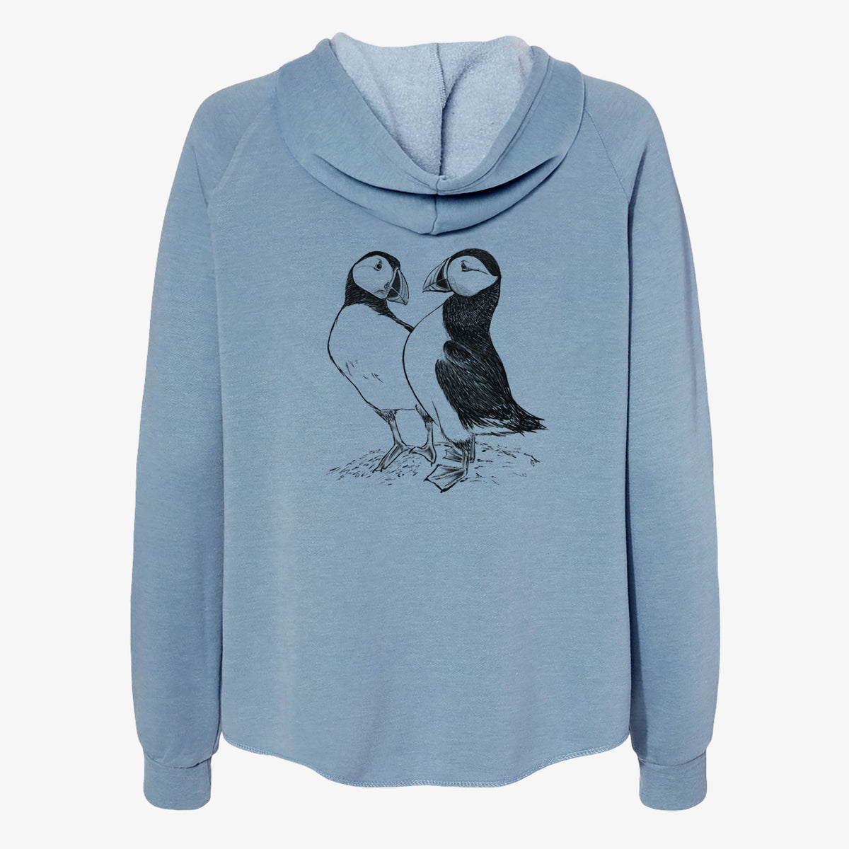 Misty blue women's Cali Wave zip-up sweatshirt laid flat, printed with a detailed black ink illustration of two Atlantic puffins standing side by side.