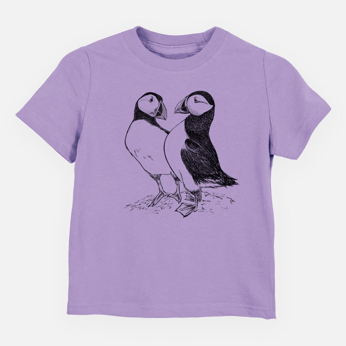 Lavender toddler t-shirt laid flat, printed with a detailed black ink illustration of two Atlantic puffins standing side by side.