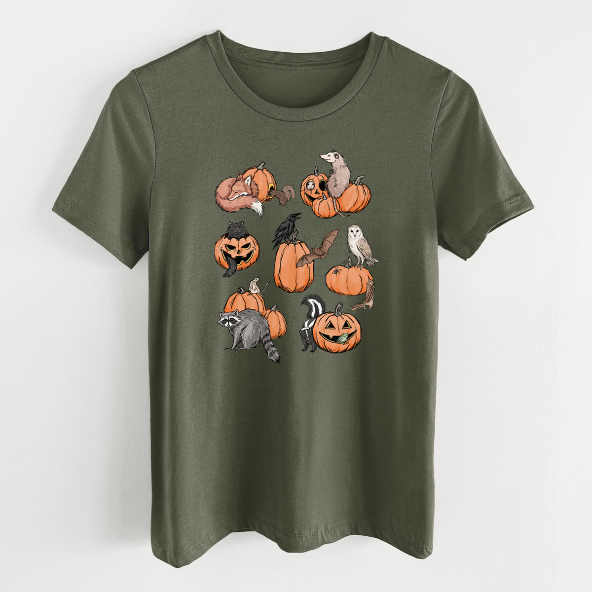 Military green women's relaxed fit cotton t-shirt laid flat, printed with orange carved jack-o'-lanterns with black ink opossums, raccoons, owls and skunks peeking out.
