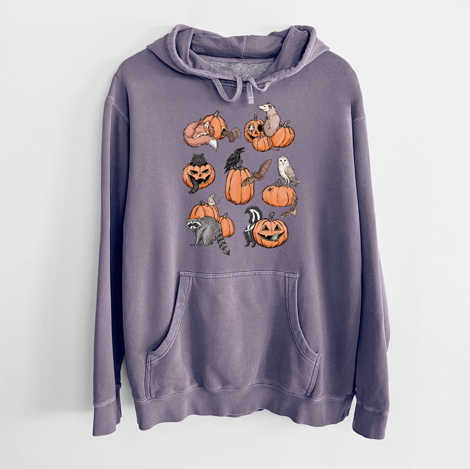 Plum purple pigment dyed hoodie laid flat, printed with orange carved jack-o'-lanterns with black ink opossums, raccoons, owls and skunks peeking out.