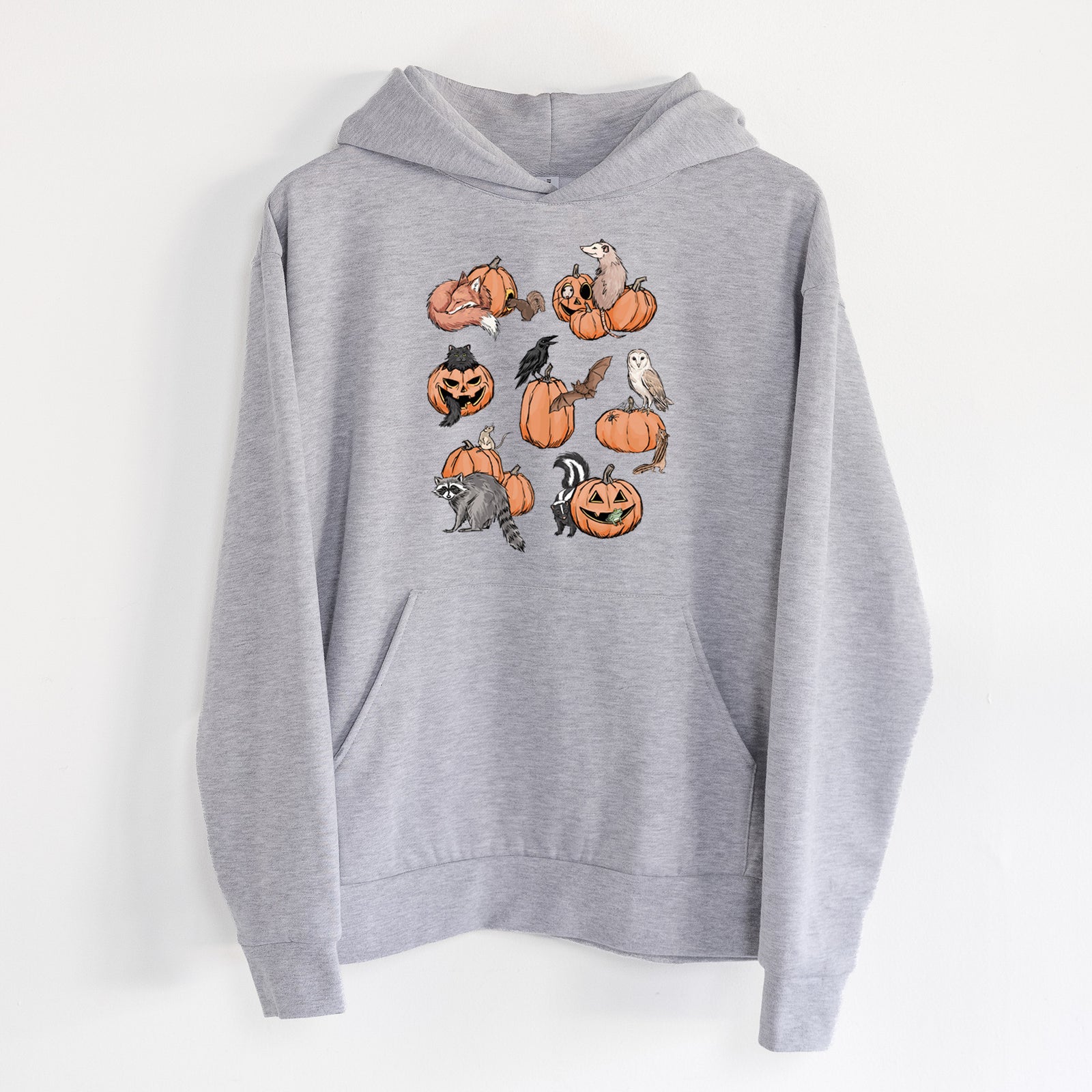 Woodland Pumpkin Patch Party - Statement Midweight Hoodie in Heather Grey, hanging on a white wall, with a front kangaroo pocket and no drawcords.