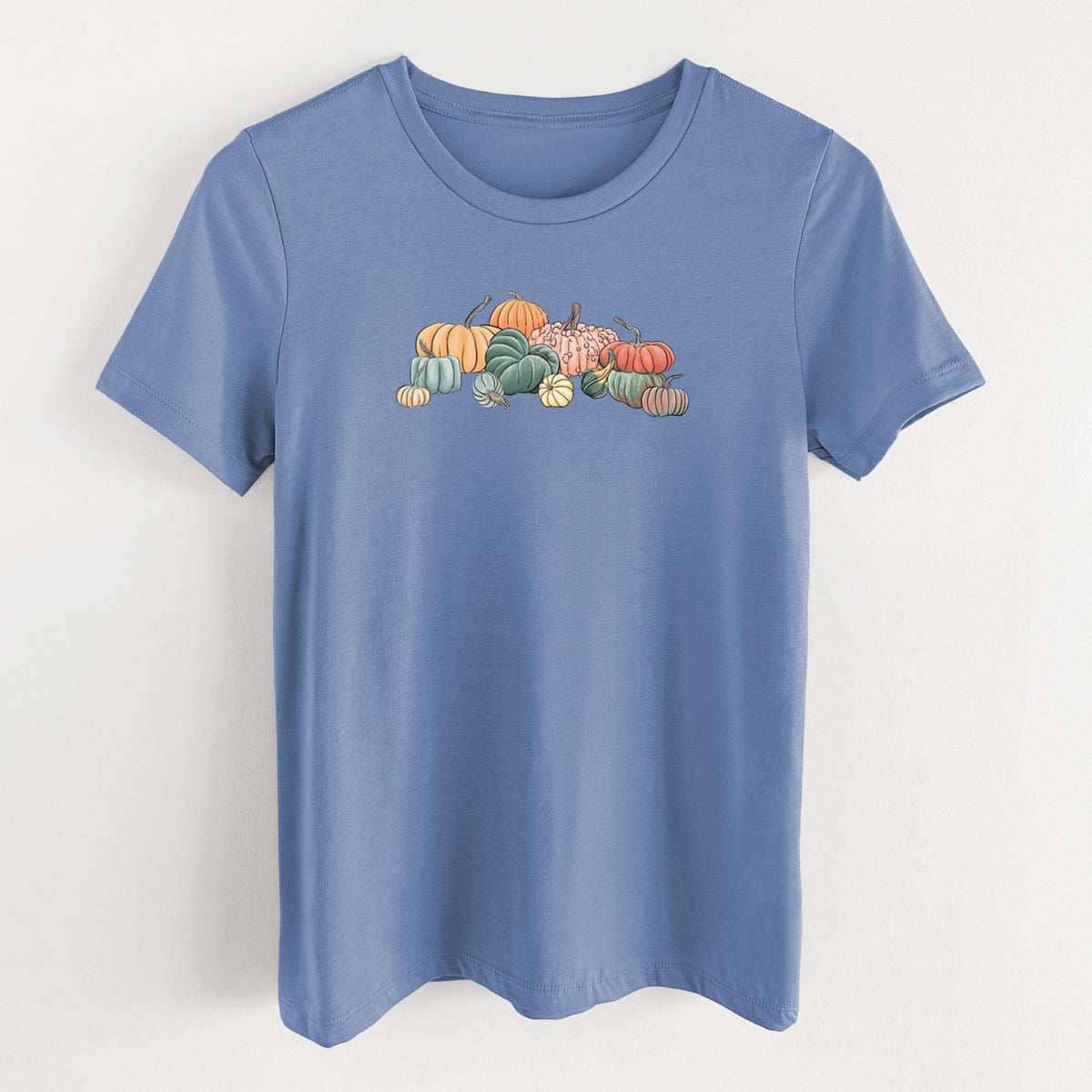 Blue bell women's relaxed fit cotton t-shirt laid flat, printed with a full-color illustration of a pile of pumpkins and gourds in orange, green and white.