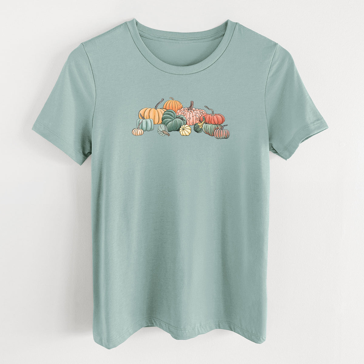 Dusty blue women's relaxed fit cotton t-shirt laid flat, printed with a full-color illustration of a pile of pumpkins and gourds in orange, green and white.