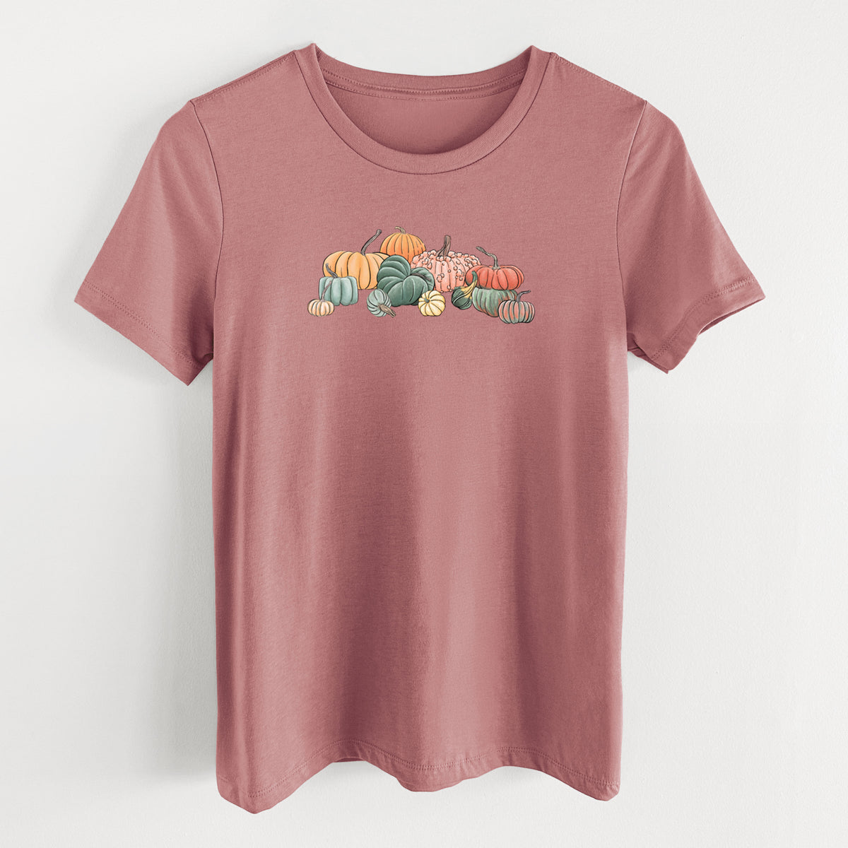 Mauve pink women's relaxed fit cotton t-shirt laid flat, printed with a full-color illustration of a pile of pumpkins and gourds in orange, green and white.