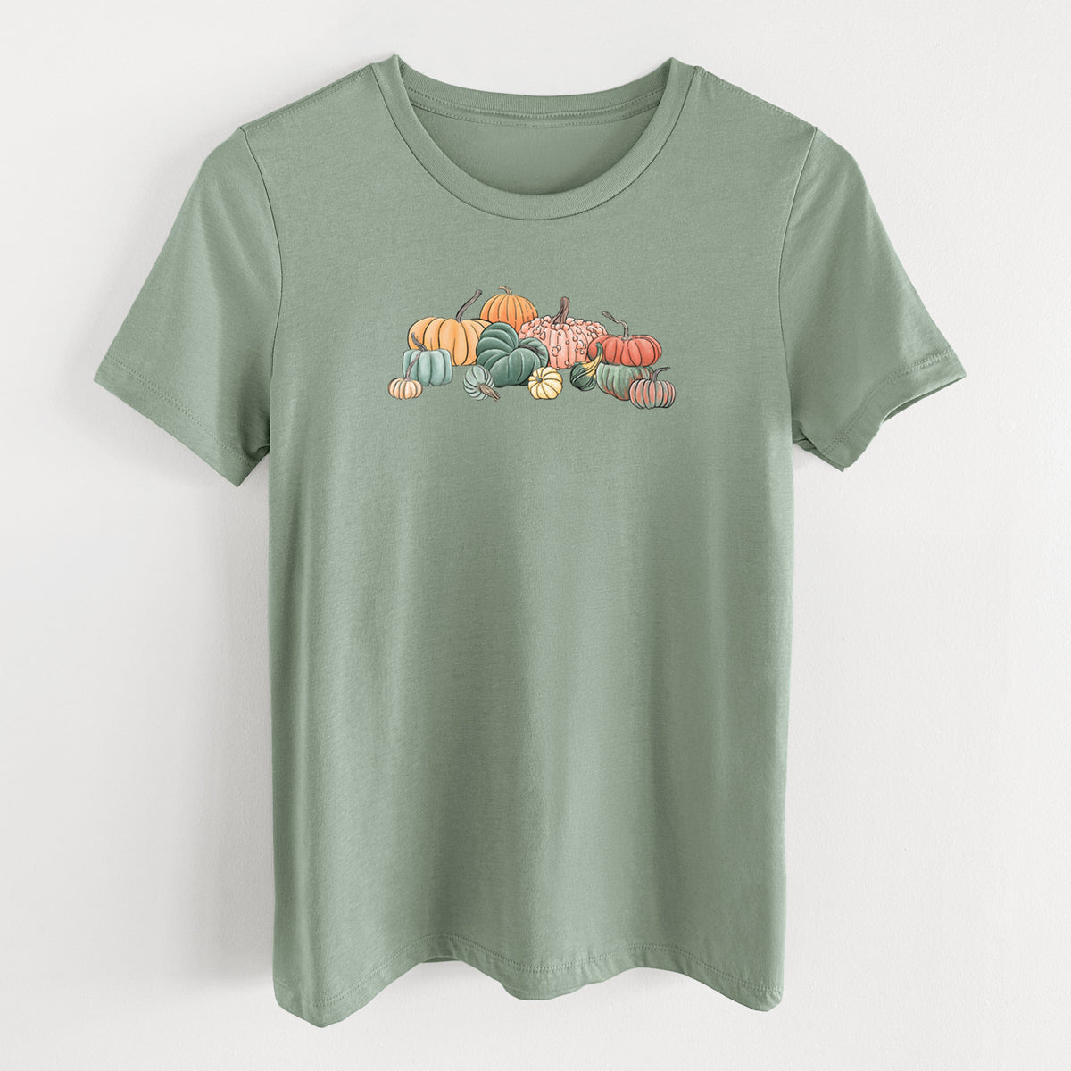 Sage green women's relaxed fit cotton t-shirt laid flat, printed with a full-color illustration of a pile of pumpkins and gourds in orange, green and white.
